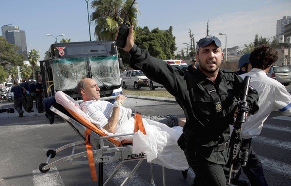 A wounded man is removed from the site of a bus bombing in Tel Aviv. 