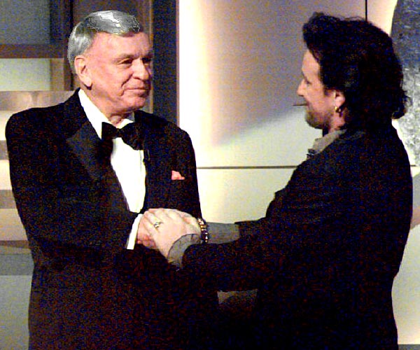 Frank Sinatra is congratulated by Bono, lead singer of the group U2, after Sinatra is honored with a Lifetime Achievement Award at the 36th Grammy Awards in 1994.