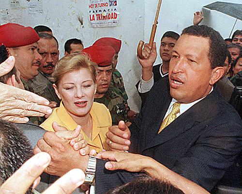 President Hugo Chavez with his wife Marisabel Chavez, shakes hands with supporters after voting on a proposed constitution. 