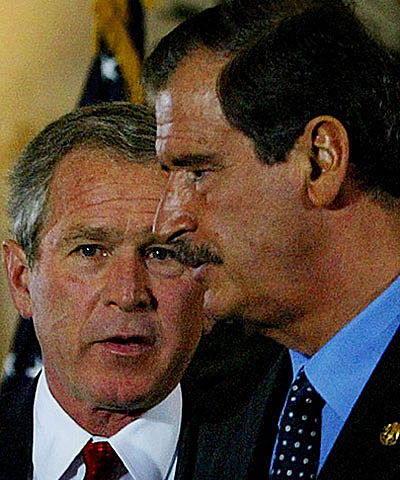 President George Bush talks with Mexican President Vicente Fox following their joint press conference during the Summit of the Americas in Monterrey, Mexico, on Jan. 12, 2004. 