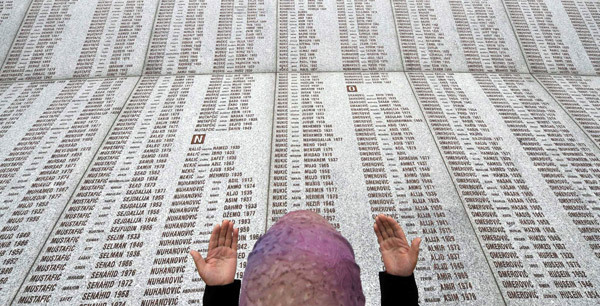 A Muslim woman prays outside Srebrenica at a memorial to the victims of the 1995 massacre.