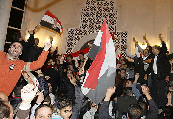 Syrians protest outside the Qatari Embassy in Damascus after a statement, read by Qatari Prime Minister Hamad bin Jassem al Thani, said the Arab League had decided to suspend Syria. 