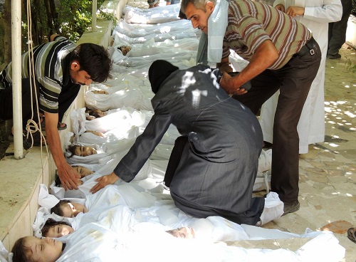 An image provided by the Syrian opposition's Shaam News Network is said to show a woman mourning over a body laid out on the ground after an alleged chemical attack in pro-rebel suburbs of Damascus.