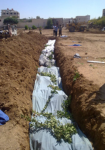 Covered bodies fill a grave reported to be in Dariya, a suburb of Damascus said to be the site of the largest mass killing to date in the Syrian conflict.