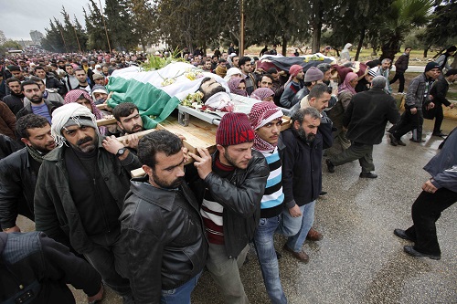 Mourners carry a body during a funeral for rebel fighters and a a 10–year–old boy killed during fighting in Idlib, Syria, in February 2012.