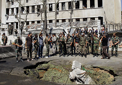 Syrian soldiers gather at the military headquarters in Damascus where two bombs went off.