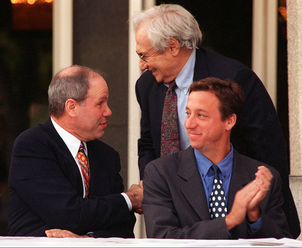 Michael D. Eisner, left, chairman and chief executive of the Walt Disney Co. greets architect Frank Gehry during presentation of a "challenge gift" toward construction of the hall. At right is Tim Disney, Walt Disney's great-nephew, whose parents Patty and Roy E. Disney pledged the first matching gift of $5 million.