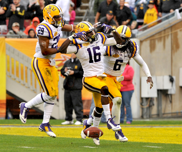 Louisiana State defensive back Tre'Davious White (15) celebrates an interception with teammates Craig Loston (6) and Rickey Jefferson (29) in the first half of the Outback Bowl. Loston would stop a late Iowa drive with an interception of his own while Jeremy Hill rushed for 216 yards and two touchdowns to help the Tigers win.