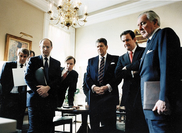 President Ronald Reagan and aides watch television coverage of the Challenger disaster.