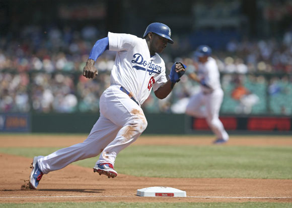 Yasiel Puig rounds third on his way to scoring a run for the Dodgers.