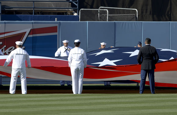 Members from the armed forces carry a flag out to center field in honor of Memorial Day before the start of the game.