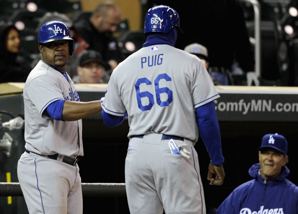 Yasiel Puig is greeted by Juan Uribe after scoring a run.
