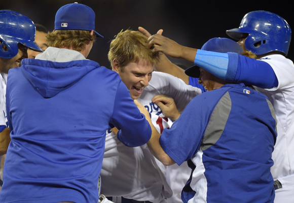 Dodgers catcher A.J. Ellis, center, is congratulated by his teammates after driving in the winning run on a sacrifice fly in the ninth inning of the team's 1-0 win over the San Diego Padres.