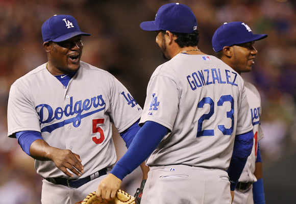 Dodgers third baseman Juan Uribe, left, celebrates with teammates Adrian Gonzalez, front right, and Erisbel Arruebarrena after the team's 3-2 win over the Colorado Rockies.