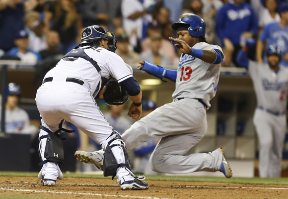 Dodgers shortstop Hanley Ramirez slides under the tag of San Diego Padres catcher Yasmani Grandal to score a run during the fifth inning of the Dodgers' 6-5 loss.