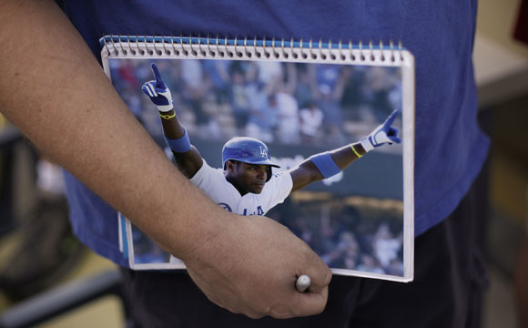 A fan holds a photo of Yasiel Puig before the game against the Marlins.