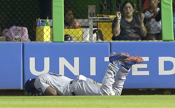 Yasiel Puig is down and injured after attempting to catch Jeff Baker's game-winning hit.