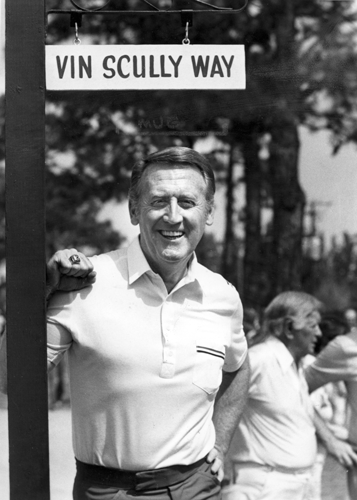 Scully stands by the Vin Scully Way street sign in Florida.