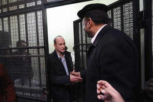 American Robert Becker, of the National Democratic Institute, leaves the defendants' cage after a court hearing March 8, 2012. He received a two-year jail term.