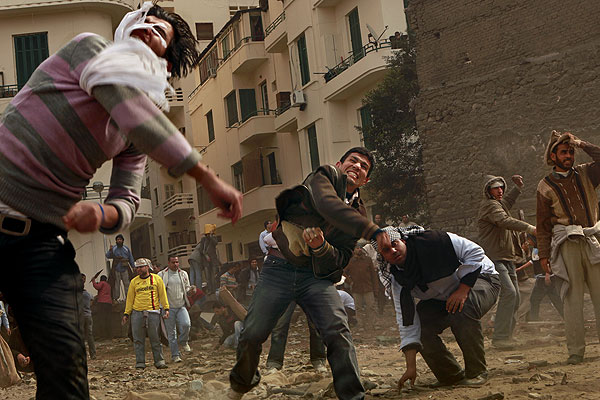Anti-Mubarak protesters throw rocks at rival group pro-Mubarak forces at the edge of Liberation Square.