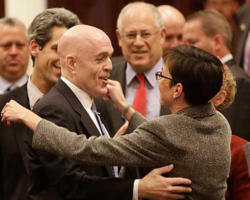 Illinois Rep. Greg Harris (D-Chicago), left, is congratulated by lawmakers after gay marriage legislation passes in the state House. Gov. Pat Quinn is center.