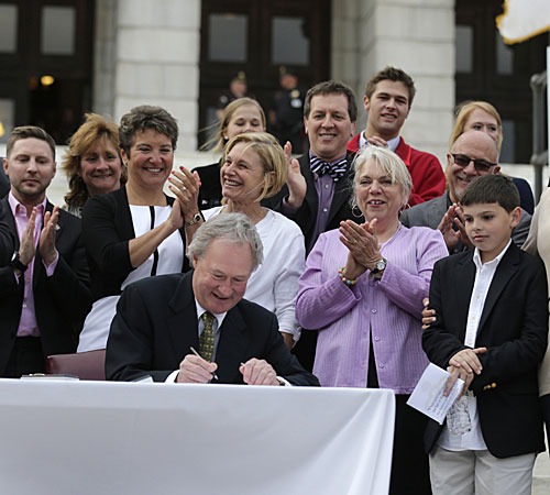 Rhode Island Gov. Lincoln Chafee signs a gay marriage bill into law outside the State House in Providence, R.I.