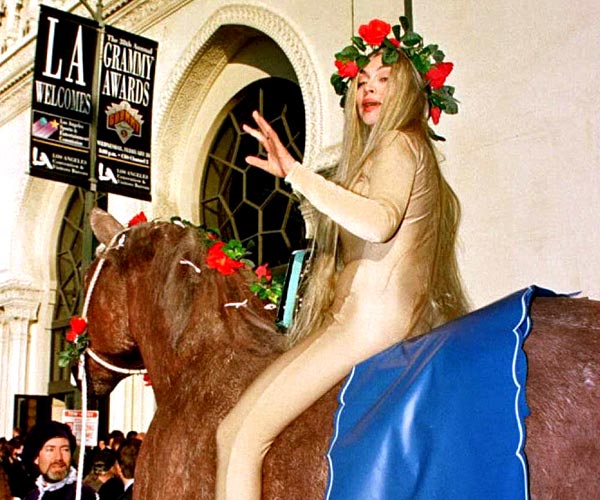 Comedian Judy Tenuta, costumed as Lady Godiva, rides a stuffed horse at the 38th Grammy Awards, expounding the cause of animal rights.