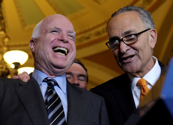 Sen. Charles Schumer (D-N.Y.), right, shares a laugh with Sen. John McCain (R-Ariz.) following an immigration reform vote in the Senate on June 27.
